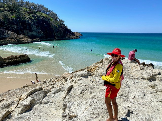 woman lifesaver standing on rock beside beach